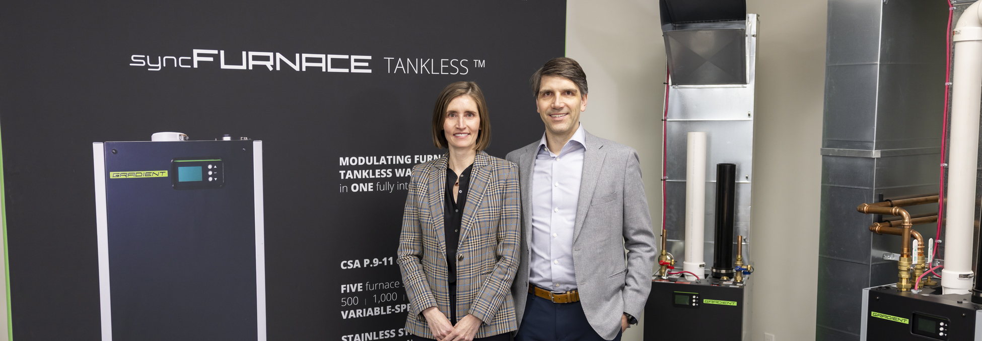 Cameron and Jennifer Doepker of Gradient Thermal standing with furnace and boiler combo
